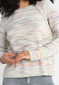 Leichtes Strickpullover aus einer Mischung von pastellfarbenen Streifen. Verfügt über ein strukturiertes Muster, einen gerippten Kragen und offene Maschen-Details an den Schultern.