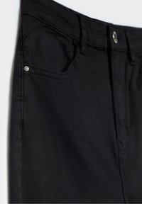 Jeans noirs au design classique avec une disposition à cinq poches, quincaillerie en métal et un tissu lisse légèrement texturé.