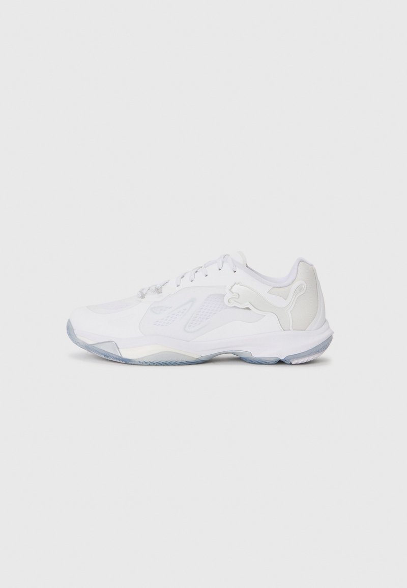 Chaussure de sport blanche avec des panneaux en maille, semelle extérieure en caoutchouc texturé et talon transparent. Présente un logo proéminent sur le côté.