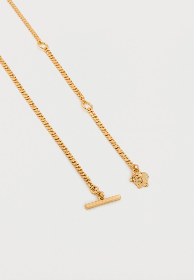 Goudkleurige ketting met een gedraaid ontwerp, voorzien van een schakel sluiting en een hanger in de vorm van een schild.