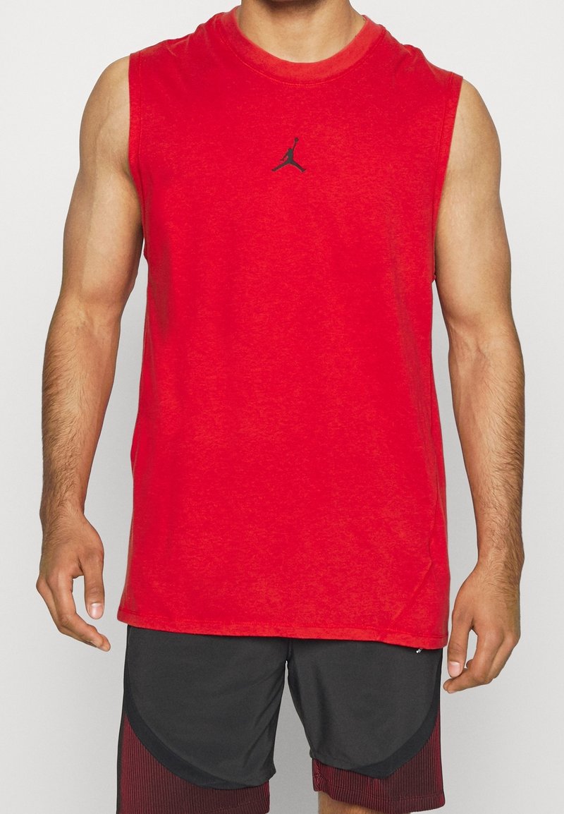 Czerwona bezrękawnik sportowy wykonany z miękkiego materiału, z małym czarnym logo Jumpman na środku. Prosty, luźny krój.
