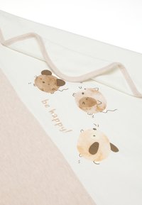 Manta de tela de color claro con una sección en triángulo beige. Presenta ilustraciones de animales juguetones y el texto "¡sé feliz!" en marrón.