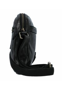 Zwarte leren tas met een gestructureerde afwerking, ritssluiting en verstelbare stoffen schouderband. Voorzien van metalen hardware en subtiele stiksels.