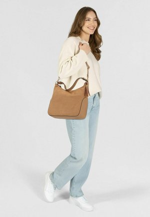 Tasche aus braunem Wildleder mit runder Form, Reißverschluss, Akzentnähten und abnehmbarem Schulterriemen. Sie verfügt über einen dekorativen Quastenanhänger.