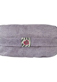 Lila tygpåse med en strukturerad yta, prydd med en dekorativ kvadratisk applikation med blommotiv och randiga detaljer.