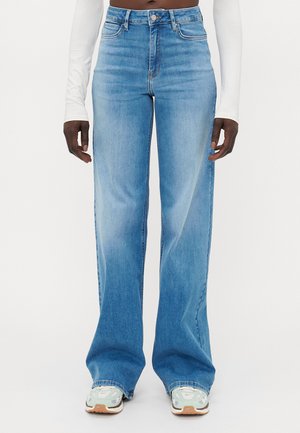Lys blå denim bukser med vid ben og høy midje, med svak falming. Avsluttet med standard søm og knapp med glidelås.