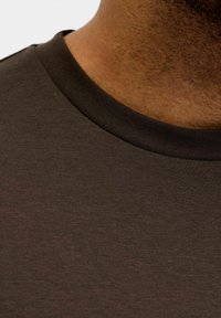 Brown t-shirt collar featuring a textured, ribbed design; fabric appears smooth and fitted with a subtle sheen.