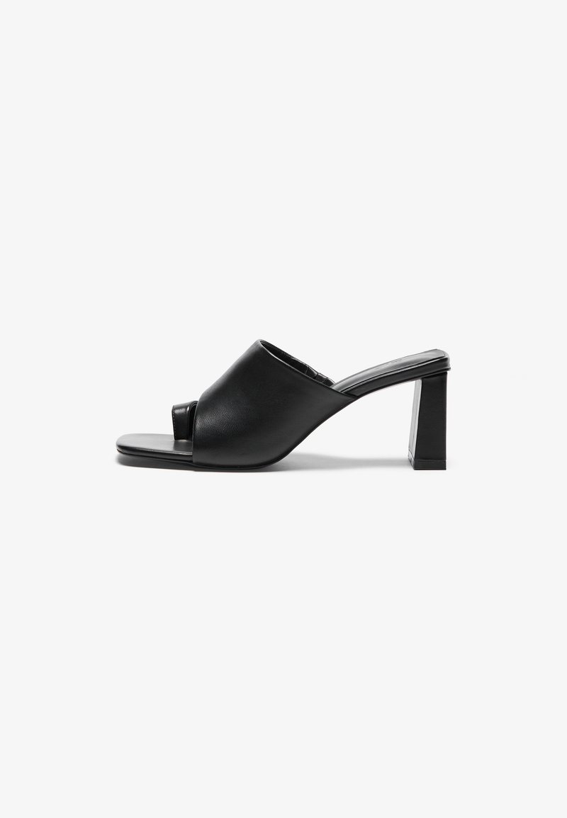 Black leather heeled mules feature an open toe design and a structured block heel. Smooth texture with minimal detailing.
