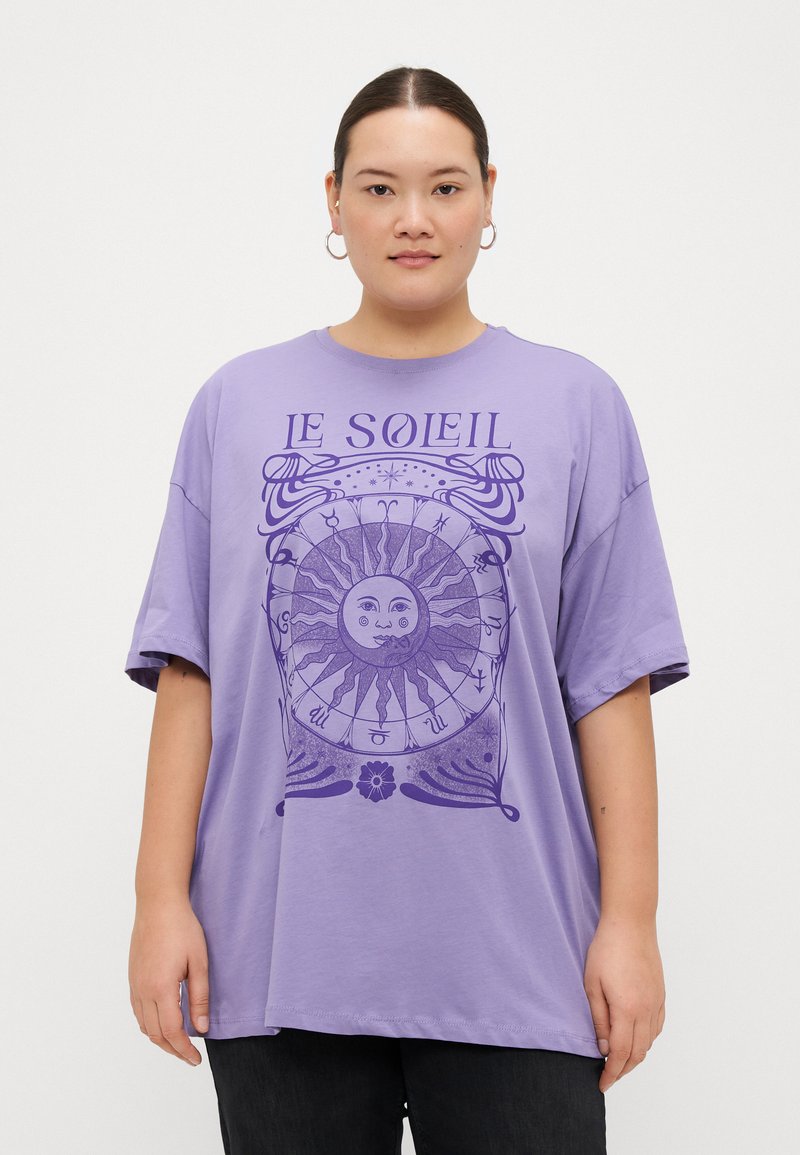 Camiseta oversized de color lavanda hecha de algodón, con un gráfico de sol y el texto "LE SOLEIL" en púrpura oscuro. Mangas cortas, corte relajado.