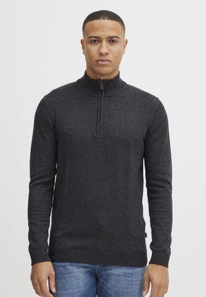 Grau zipfeliger Pullover aus einem weichen, strukturierten Stoff. Verfügt über lange Ärmel, einen hohen Kragen und einen gerippten Saum. Einfaches und schmuckloses Design.