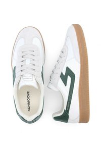Weiße Turnschuhe mit grünen Akzenten und Wildlederdetails, ausgestattet mit einer Gummisohle, Schnürdesign und einem Logo auf der Zunge und der Seite.