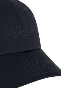 Černá baseballová kšiltovka vyrobená z látky, s vyvýšeným vyšíváním "HACKETT LONDON". Zakřivený kšilt s viditelným švem a logem na straně.