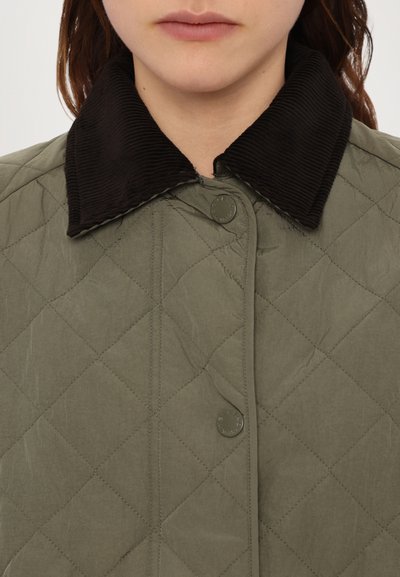 Quilted olivgrüne Jacke mit einem dunklen Cordkragen und einer Frontknopf-Leiste. Merkmale ein rautenförmiges Steppmuster.