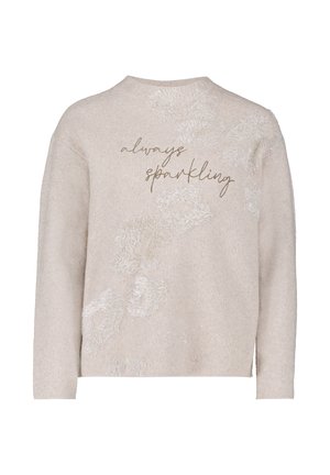 Crème trui met een fuzzy structuur, voorzien van "altijd sprankelend" in metallic gouden schrift en abstracte pluizige accenten op de voorkant.