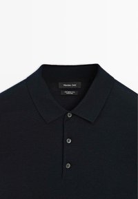 Dunkelblaues Polohemd aus 100 % Merinowolle. Mit klassischem Kragen, drei Knöpfen und strukturiertem Stoff. Sichtbares Massimo Dutti-Branding.