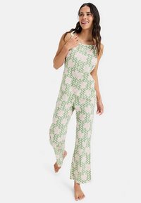 Overal s kvetinovým vzorom v zelenej a ružovej farbe, vyrobený z ľahkej tkaniny. Má voľný strih, široké nohavice a nastaviteľné ramienka.