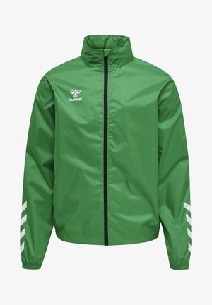 Chaqueta cortavientos verde con cremallera, cuello alto, logo blanco de hummel en el pecho y franjas blancas en forma de chevron en las mangas.