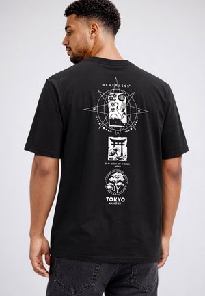 Man wearing black T-shirt with white Japanese-themed graphics, including crane, Mount Fuji, torii gate, and tree, labeled "Tokyo Kanto."