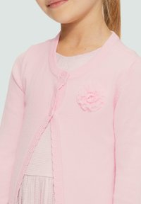 Lichtroze gebreide cardigan met geribbelde randen, een knoopsluiting en een gemêleerd bloemenaccent aan de linkerkant. Zachte, getailleerde pasvorm.