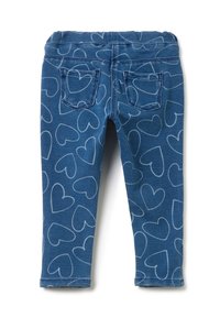 Leggings de mezclilla con un fondo azul y patrones de corazones blancos, que cuentan con una cinturilla elástica y dos bolsillos traseros.