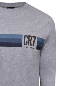 Grå langærmet skjorte med rund hals, der har blå og marineblå vandrette striber samt teksten "CR7 NIGHTWEAR" trykt på forsiden.