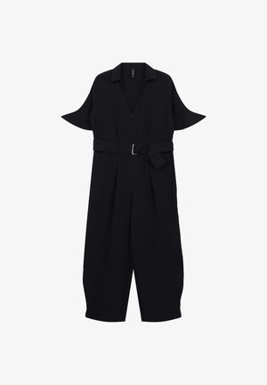 Combinaison noire à manches courtes, col et ceinture à la taille. Présente un décolleté en V profond et des jambes courtes larges.