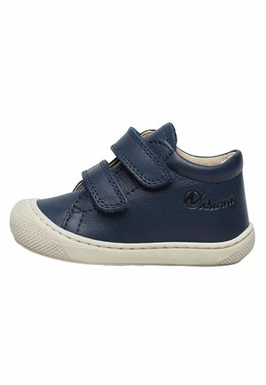 Chaussure en cuir marine avec deux bandes Velcro, semelle en caoutchouc blanche et capuchon de pointe texturé ; présente un logo en relief sur le côté.