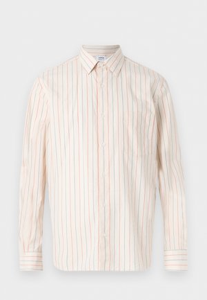 Camicia bianca a maniche lunghe con bottoni, con strisce verticali rosse e blu e una tasca singola sul petto, distesa su uno sfondo bianco.