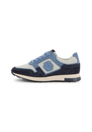 Zapatilla de caña baja en malla azul y gris con superposiciones de ante, cordones delanteros y suela beige con dibujo negro.
