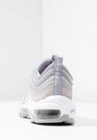 Grå mocka och meshsneaker med en vågig design, vadderad krage, Air Max-logotyp och transparent luftkuddar på en vit sula.