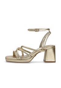 Las sandalias de tacón cuadrado doradas con tiras presentan un acabado metálico, una amplia correa en el tobillo con hebilla y múltiples tiras cruzadas para mayor soporte.