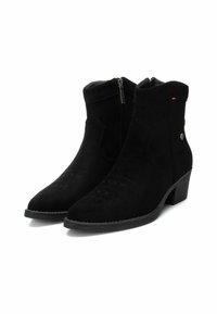 Stivaletti neri in suede con tacco basso, chiusura a zip, cuciture decorative sulla punta e un sottile dettaglio del logo di lato.