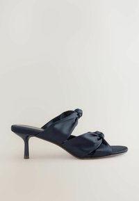 Jūras spēku satīna papēžu mūles ar savītu jostu un atvērtām purngalēm, ar šauru papēdi un gludu tekstūru eleganta izskata sasniegšanai.
