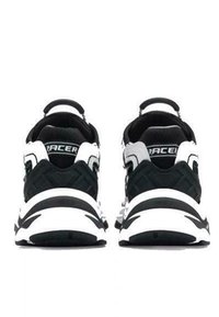 Mustat ja valkoiset urheilukengät ovat varustettu pyöreällä varpaalla, tekstuurilla varustetulla kankaalla, pehmustetulla nilkkapäällä ja kumipohjalla, jossa on selkeä kerrostettu muotoilu.