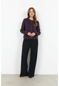 Cardigan tricotat mov cu guler rotund, butoane frontale și mâneci lungi, purtat cu pantaloni largi negri și pantofi slip-on maro.