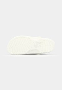 Sandale slide en caoutchouc blanc avec une semelle texturée à motif chevron et un détail de branding, conçue pour le confort et l'adhérence.