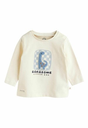 Krémová košeľa s dlhým rukávom, na ktorej je modrá grafika dinosaura na kockovanom pozadí, s textom "ROARSOME LITTLE ONE." Mäkkučký materiál.