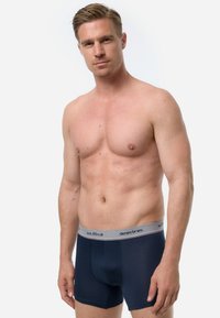 Navyblaue Baumwoll-Boxershorts mit einem grauen Bund, der das Logo "denim bros." trägt. Enganliegendes Design mit einer glatten Textur und ohne Muster.