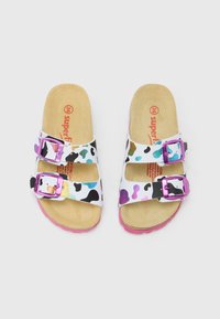 Sandale albe cu model colorat cu pete și catarame mov, având o talpă căptușită de culoarea brânzei și o talpă exterioară roz din cauciuc.