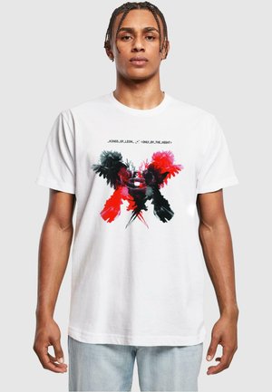White cotton t-shirt featuring a graphic print of black, red, and pink feathers in an abstract design. Text reads "_KINGS_OF_LEON_ 'ONLY_BY_THE_NIGHT'."