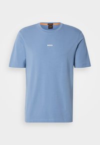 T-shirt bleu clair à manches courtes avec texte blanc "BOSS" centré sur la poitrine et un col rond avec un détail orange à l’intérieur du col.