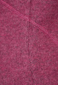 Texturerad tyg i en djup rosa nyans med subtila grå trådar, med en sömlös design och kontrasterande sömnadsdetaljer.