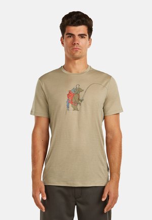 Mann trägt beige T-Shirt mit Grafik eines Bären im orangefarbenen Rucksack, der eine Angelrute mit einem daran hängenden Fisch hält.