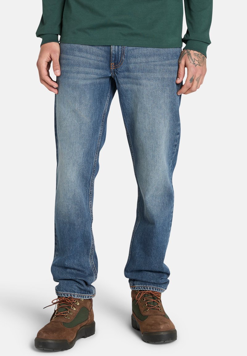 Verblasste blaue Jeans im geraden Schnitt, mit einem klassischen Fünf-Taschen-Design und dezenten Nähdetails entlang der Nähte.