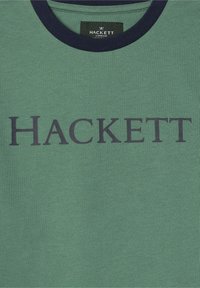 Grön bomull T-shirt med en texturerad yta, med en marinblå ribbad rund hals och stor svart "HACKETT" tryck över framsidan.