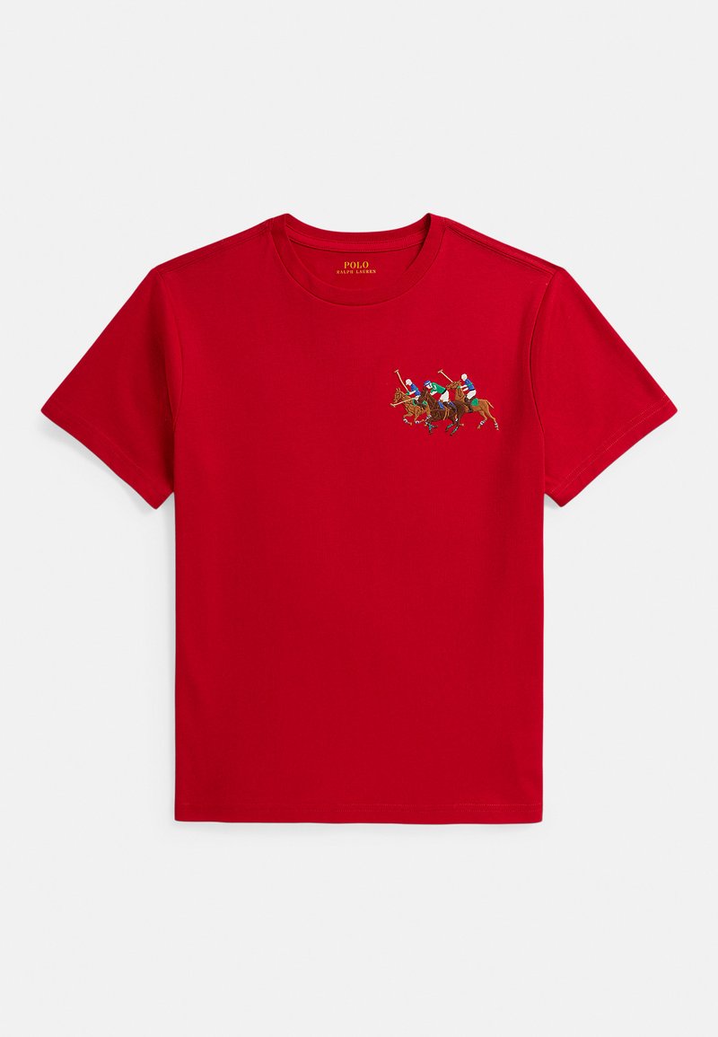 Červené bavlněné tričko s malým vyšívaným motivem tří jezdeckých postav se šavlemi. Krátké rukávy a kulatý výstřih.