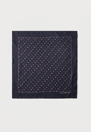 Tengerészkék négyzet alakú sál apró fehér és piros geometriai mintákkal, valamint vékony fehér szegéllyel a széleken.