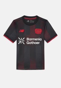 Čierny futbalový dres s červenými akcentmi, s textúrovaným vzorom, okrúhlym výstrihom a logami New Balance a Bayer 04 Leverkusen.
