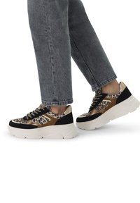 Leopard print platform sneakers featuring black suede, gold accents, and thick white rubber soles. Laced design with textured fabric elements.