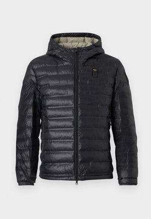 Chaqueta negra acolchada con capucha, cremallera frontal, pequeños parches en el pecho y la manga, y puños elásticos.